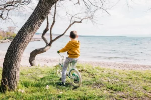 Junge bei Radreise mit Fahrrad am see